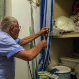 Uno scaffale celato da una tenda a strisce bianche e blu conserva le reti in cotone e nylon...